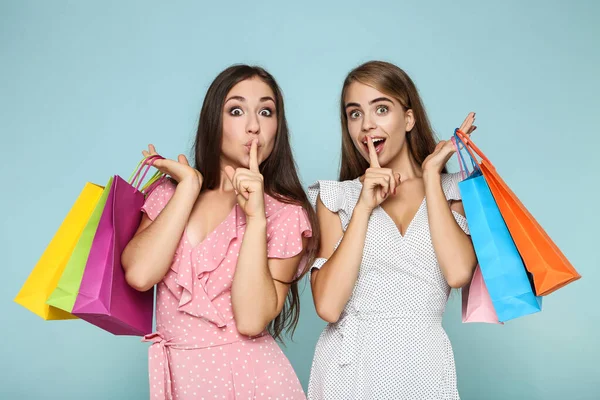Junge Glückliche Freundinnen Mit Einkaufstaschen Auf Blauem Hintergrund — Stockfoto