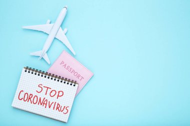 Mavi zemin üzerinde pasaport ve uçak modeli olan Coronavirus 'u Durdur
