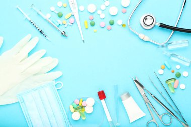 Doktor Günü konsepti. Mavi arka planda renkli hapları olan ilaç araçları