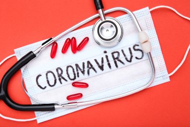 Coronavirus 'a kırmızı arka planda haplar ve steteskopla mesaj at.