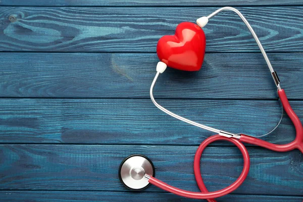 Stetoskop Czerwonym Sercem Niebieskim Drewnianym Stole — Zdjęcie stockowe