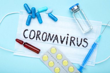 Coronavirus 'a mavi arka planda haplar, şırınga ve tıbbi ampul gönder.