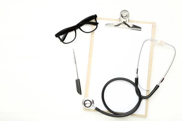 Stetoskop Schowkiem Długopisem Okularami Białym Drewnianym Stole — Zdjęcie stockowe