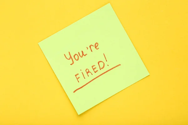 Text You Are Fired on paper on yellow background