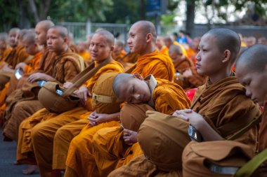 Chiang Mai, Tayland - 26 Aralık 2015: Sabahın erken saatlerinde geleneksel Budist sadakaları sırasında uyuyan genç keşiş.