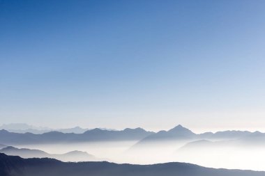 Güzel dağ silsilesi arka plan mavi gökyüzü ve beyaz sabah erken güneş siste.
