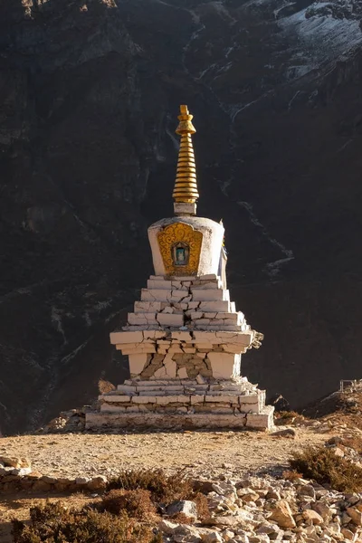 Estupa budista en Thame pueblo con pared de montaña rocosa en el fondo, Parque Nacional Sagarmatha, Himalaya . — Foto de Stock
