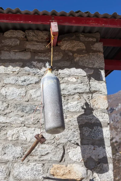 Old oxygen bottle and hummer work as a school bell in the remote Himalayan school of Thame village, Nepal.
