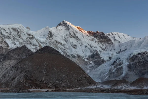 Wunderschöner Sonnenuntergang über dem Berg cho oyu, der sich im grauen Moränensee spiegelt, der mit Eis bedeckt ist. — Stockfoto