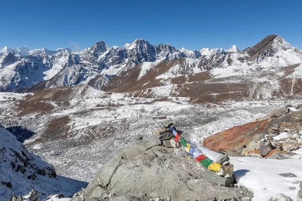 Bandeiras de oração budistas em cairns de montanha na rota do acampamento base do Everest no Himalaia, Nepal . — Fotografia de Stock