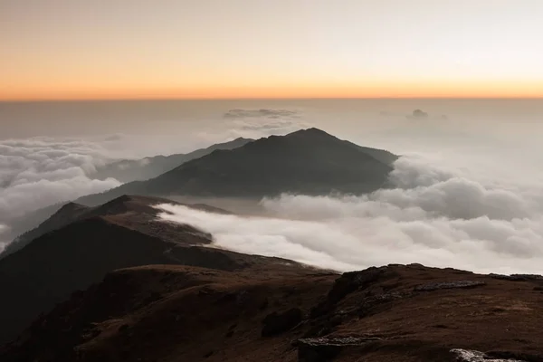 Malebná krajina údolí plné kudrnaté mraky při východu slunce. — Stock fotografie