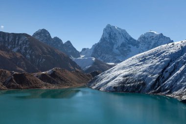 Gokyo Gölü turkuaz suları altında açık mavi gökyüzü güneşli bir günde inanılmaz güzel sahne.