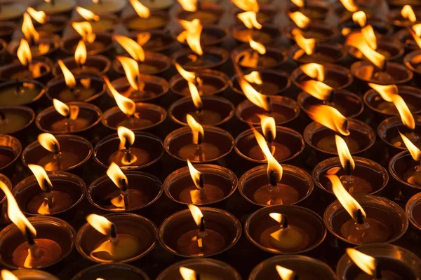 A ground of burning candles lighting up at Boudhanath Buddhist temple in KathmanduNepal Beautiful