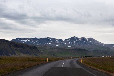 Kar kırsal İzlandaca ufuk boş yolda İzlanda yol Dağları ile kaplı