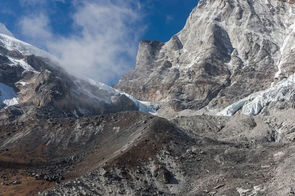 Szary lodowiec schodzili z góry wielkie skały pokryte śniegiem w pogodny dzień góry Himalaya — Zdjęcie stockowe