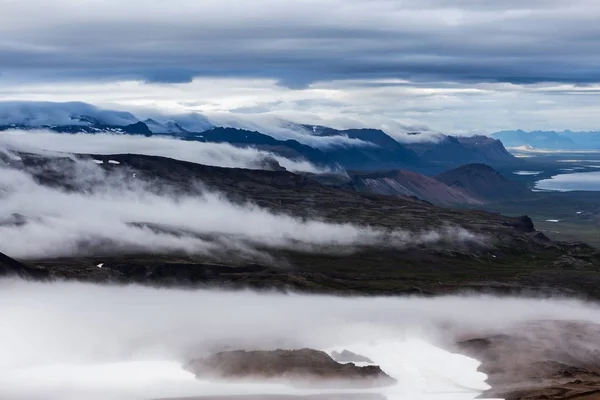 Nubes que fluyen bajo en la hermosa vista del paisaje de montaña de Islandia desde la pendiente de — Foto de Stock