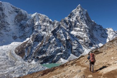 Bir yükseklik dağ tepe ve Himalaya mavi buzultaş göle doğru Nepal'de trekking etkin uzun yürüyüşe çıkan kimse
