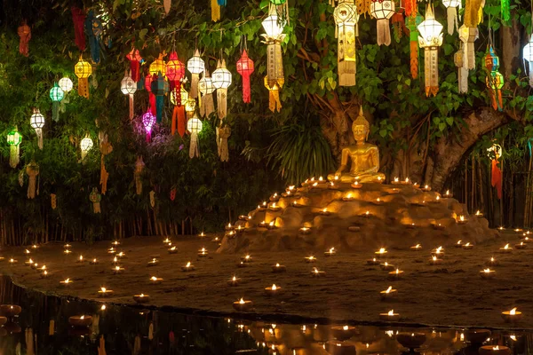 Estátua de Buda cercada por velas e lanternas coloridas — Fotografia de Stock