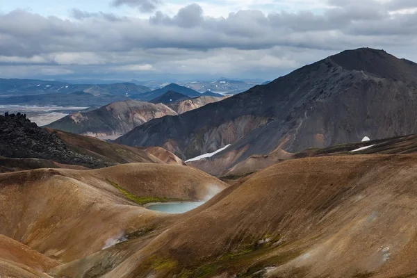 Dramatic Iceland scenery with colorful rhyolite mountains heavy gray clouds and small volcanic — Stock Photo, Image