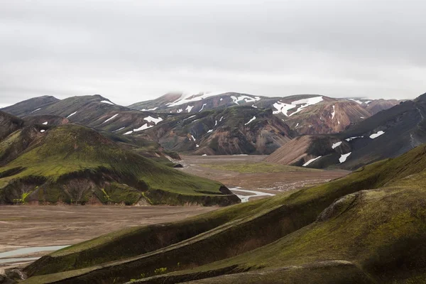 Dramatische landschap van IJsland met besneeuwde gletsjer op de horizon en de groene bergen bedekt met dikke — Stockfoto