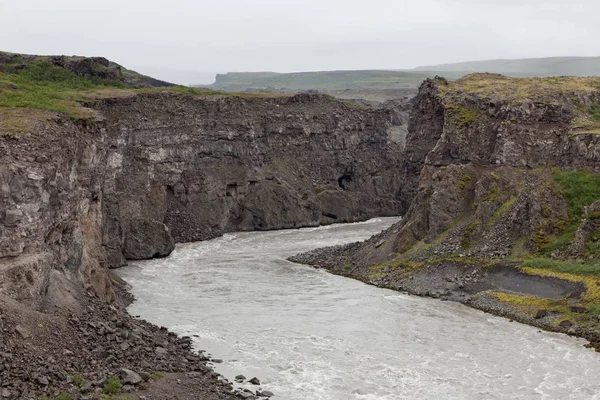 IJsland rivierlandschap op een grijze, bewolkte dag rivier omgeven door grote rotsen rotsen vallen neer — Stockfoto