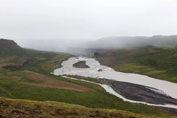 Islandia paisaje fluvial en un día gris brumoso Río rodeado de grandes acantilados Roca volcánica — Foto de Stock