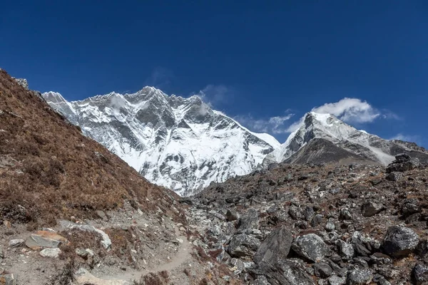 Hiking trail in Everest Base Camp Trek with Lhotse South Face wall on the horizon Extreme hicking