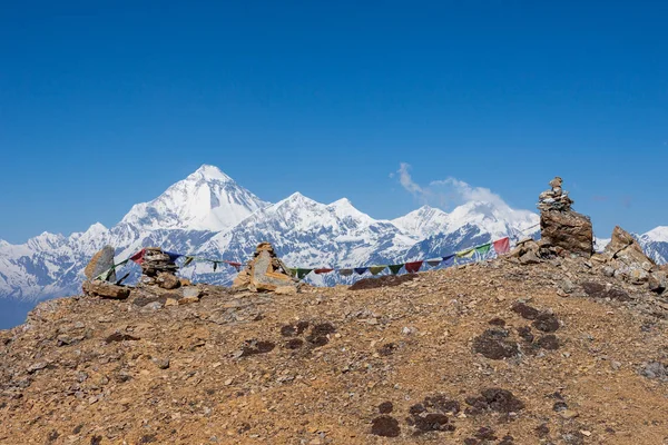 Bandiere buddiste di preghiera sui cairn dell'Himalaya con mt Dhaulagiri sullo sfondo — Foto Stock