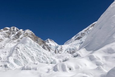 Güzel kar ve buz Dağları görünümü kadar tepeler ve mavi gökyüzü beyaz bulutlar ile kaplı