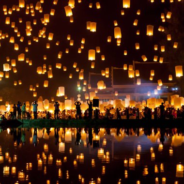People release sky lanterns to pay homage to the triple gem Budhha Dharma and Sangha during Yi clipart