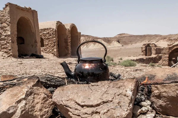 Hervidor de té en fogata en el desierto iraní Dashte Kavir cerca de la aldea abandonada — Foto de Stock