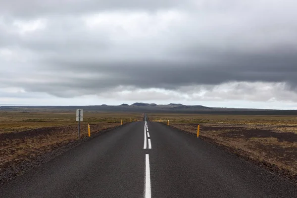 Islandia carretera que conduce directamente a las montañas lejanas Línea recta vacía en islandés rural — Foto de Stock