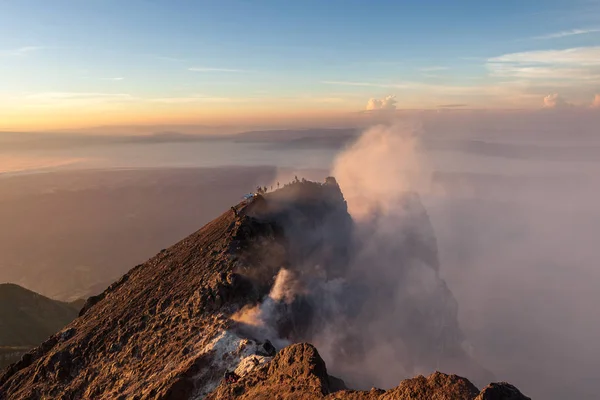 Okraje kráteru sopky Merapi s lidmi, lezení po summitu v sunrise kouření caldera v Javě — Stock fotografie