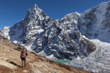 Bir yükseklik dağ tepe ve Himalaya mavi buzultaş göle doğru Nepal'de trekking etkin uzun yürüyüşe çıkan kimse