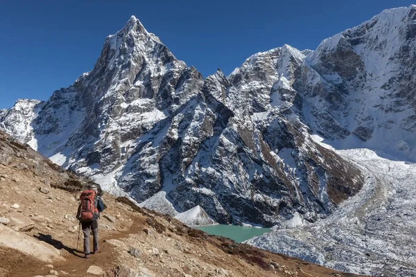 Bir yükseklik dağ tepe ve Himalaya mavi buzultaş göle doğru Nepal'de trekking etkin uzun yürüyüşe çıkan kimse