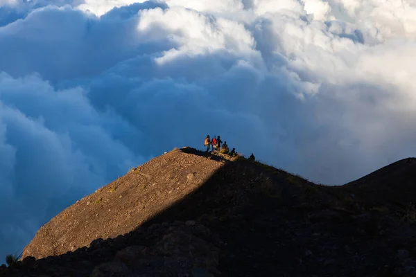 Skupina turistů nad mraky sestupující z vrcholu Agung Mountain Bali — Stock fotografie