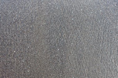 Black sand on a beach Can be used as a background or texture