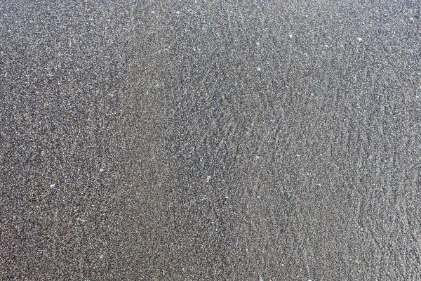 Arena negra en una playa Se puede utilizar como fondo o textura —  Fotos de Stock