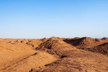 Lut desert in Iran Sandy and rocky dunes in the Iranian desert with blue sky Beautiful cover or clipart