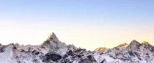 Himalayan mountain range Banner sized photo with Ama Dablam peak and blue sky