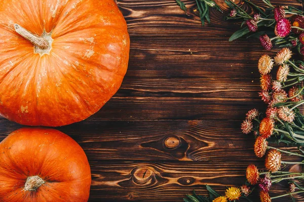 Cadılar Bayramı kavramı ile taze kabak ve ahşap masaya çiçek. Şeker ya da numara yukarıdan görünüm