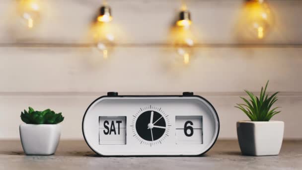 A white flip clock on table turns through month, flipping days and date, countdown from 1st to 31th — Stock Video