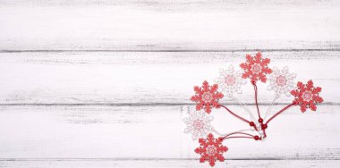 Kırmızı ve beyaz kar taneleri beyaz ahşap arka planda Noel ağacı için oyuncaklar.