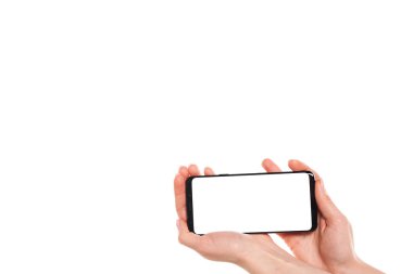 Beyaz arkaplanda modern çerçevesiz tasarımı olan siyah akıllı telefonu tutan kadın elleri