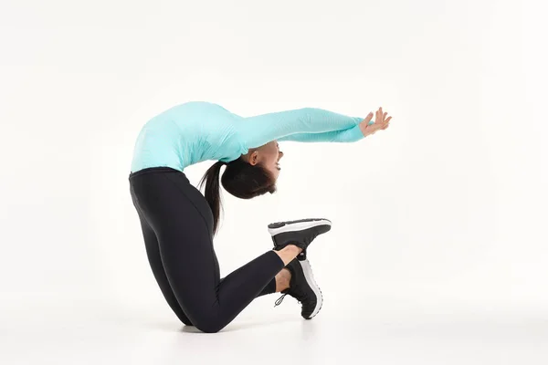 Ung atletisk kvinna som gör yoga och gymnastik stretching övningar isolerade på vitt — Stockfoto