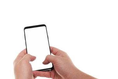 Beyaz zemin üzerinde modern çerçevesiz tasarım ile siyah akıllı telefon boş ekranda yazı yazan insan elleri