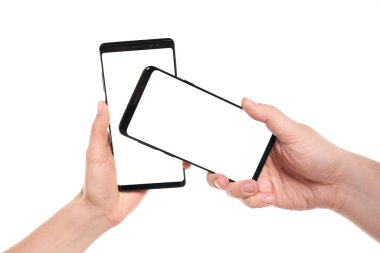 İki el akıllı telefonları boş ekranla modern çerçevesiz tasarım ile tutarken kablosuz veri transferi Nfc beyaz arkaplanda izole edildi