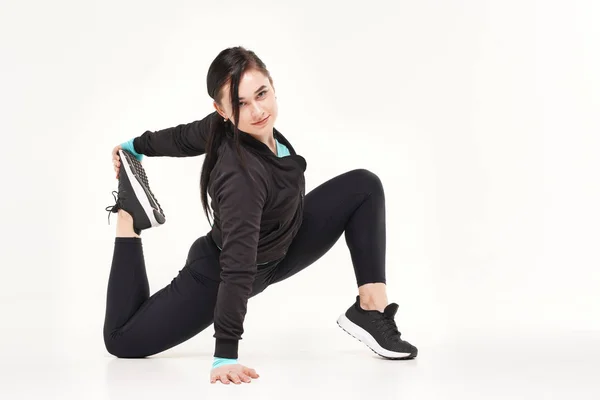 Молодая спортсменка делает йогу и гимнастику растяжения упражнения изолированы на белом — стоковое фото