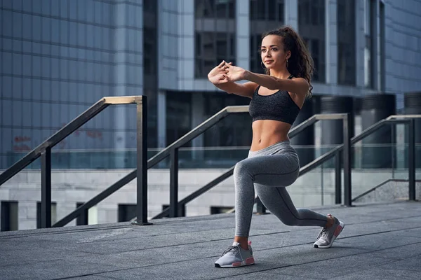 Jonge atletische vrouw stretching in het stadion van de stad, training op stedelijke locatie — Stockfoto