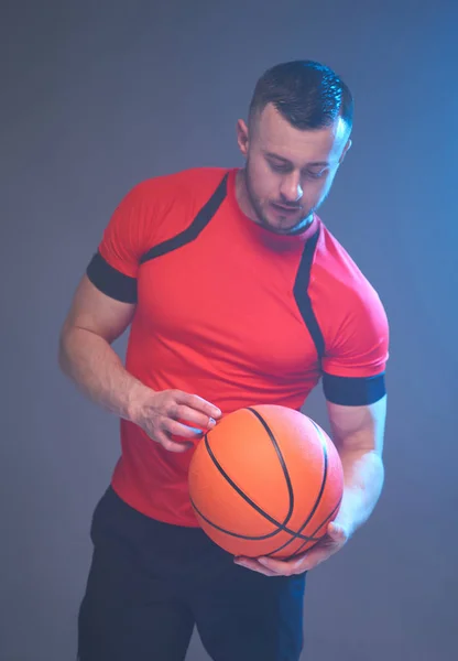 Focus op bal schot waar de man die basketbal met een hand in de voorkant van grijze rokerige achtergrond — Stockfoto